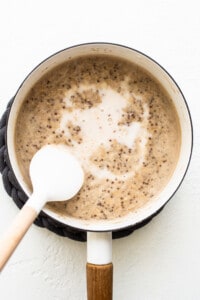 A pot of coffee with a spoon in it.