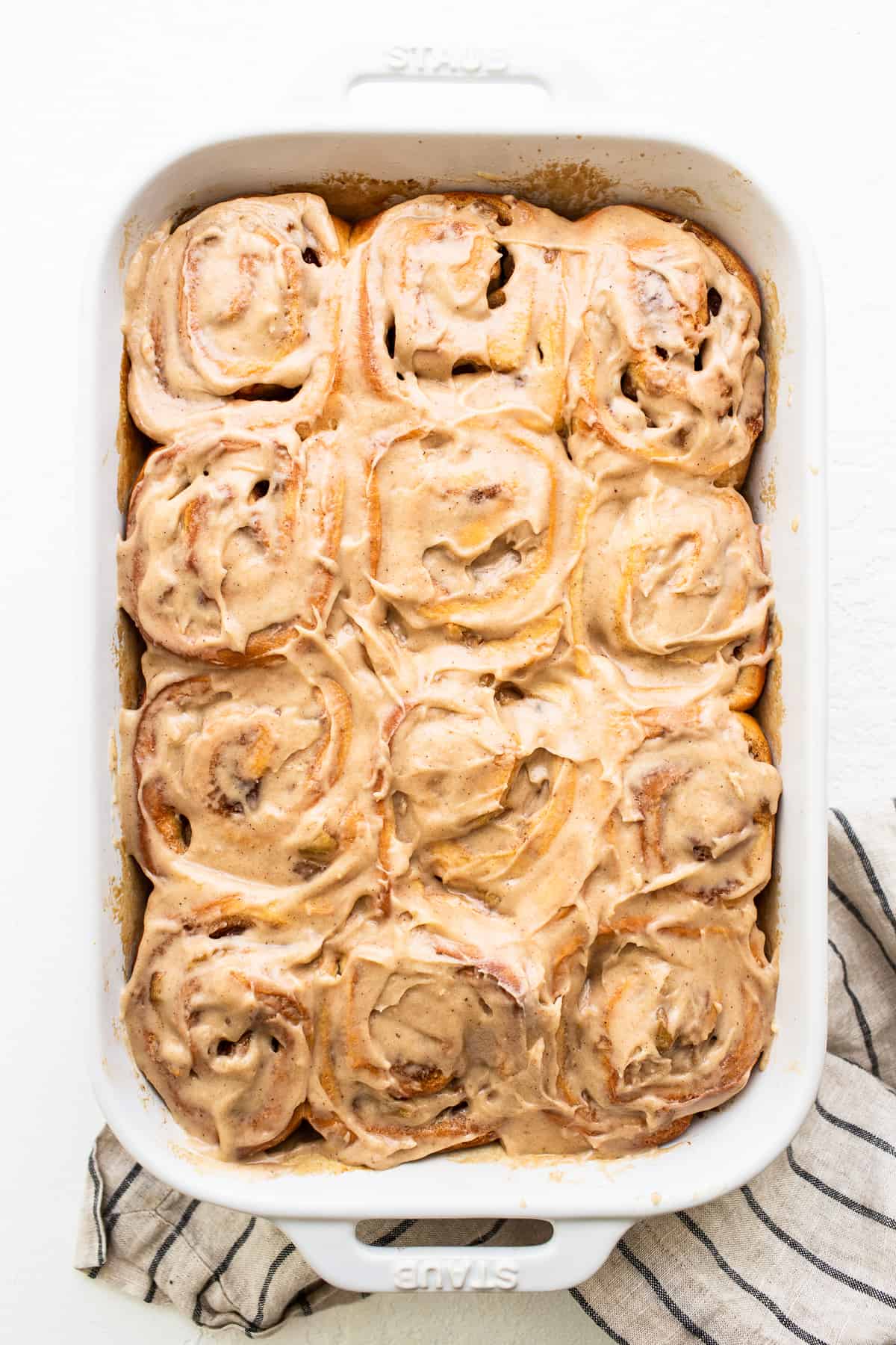 Apple cinnamon rolls covered in brown butter cream cheese frosting.