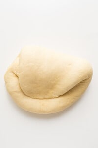 A loaf of dough on a white surface.