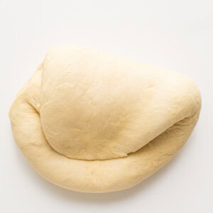 A loaf of dough on a white surface.
