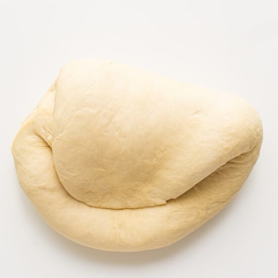 A loaf of dough on a white surface.