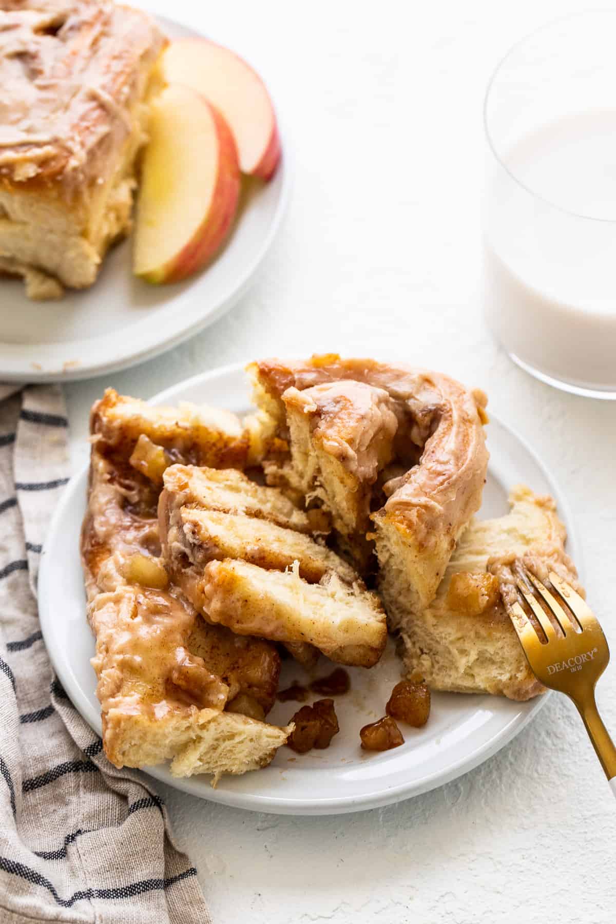 Apple cinnamon roll on a plate with a fork.