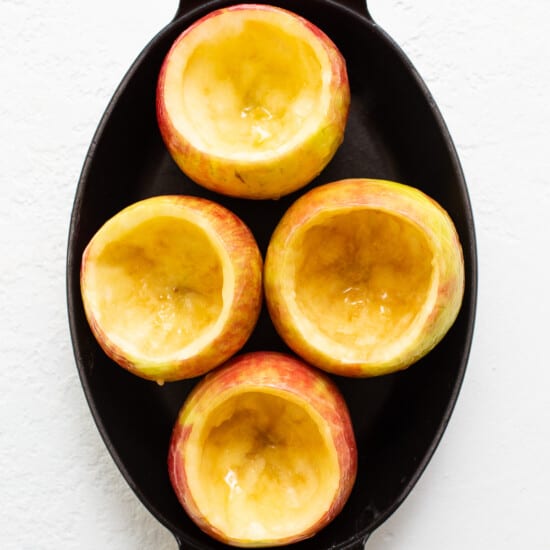 Sliced apples in a skillet on a white background.