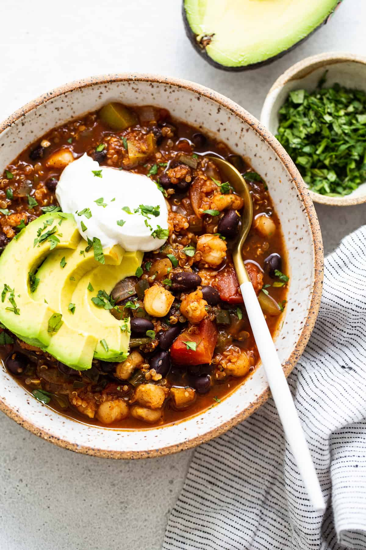 quinoa chili topped with avocado and sour cream.