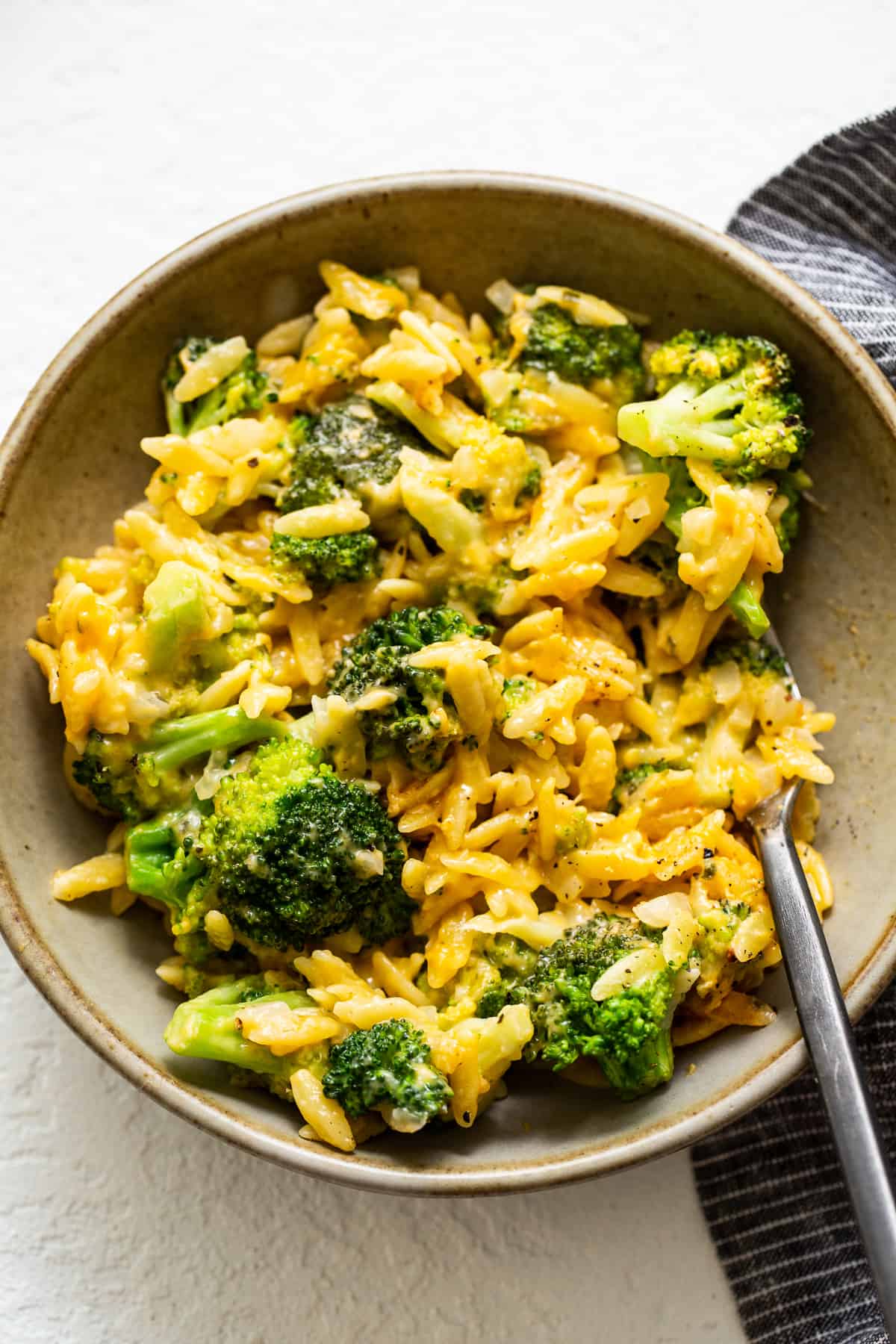 broccoli and cheese casserole in a bowl with a fork.