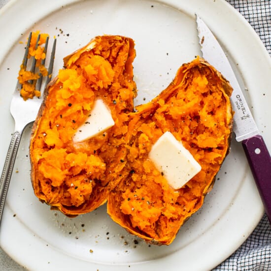 Une patate douce sur une assiette avec du beurre.