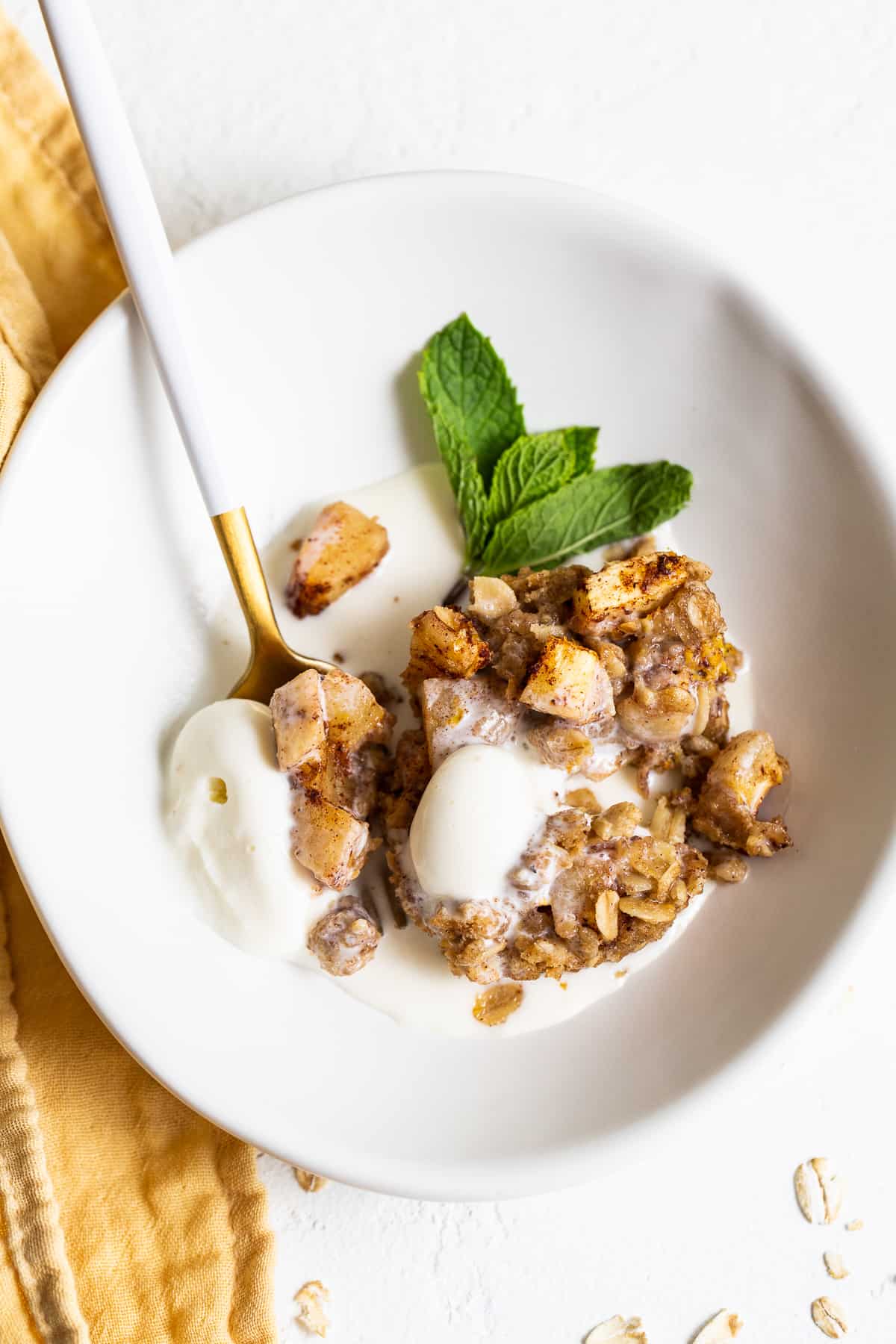 mini apple crisp in bowl with ice cream.