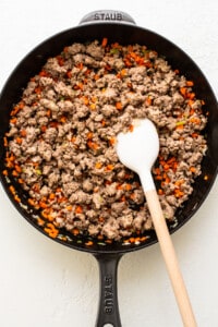 A skillet filled with ground beef and carrots.