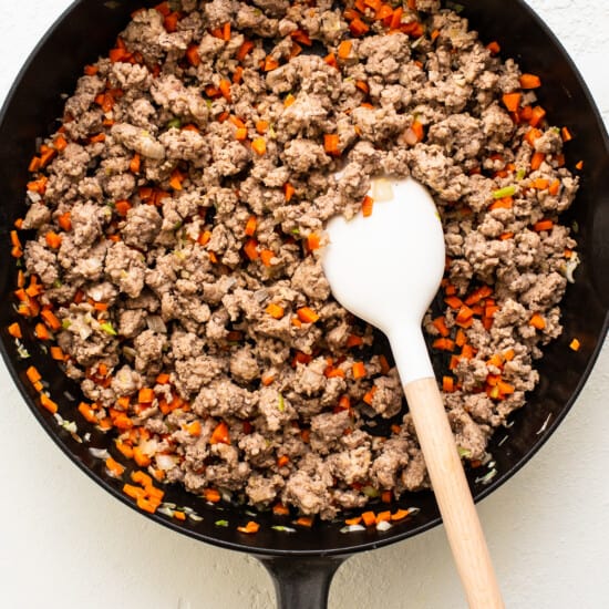 A skillet filled with ground beef and carrots.
