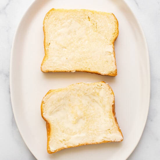 Two slices of bread on a white plate.