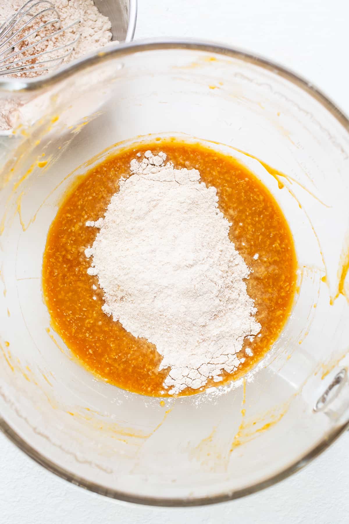 adding dry ingredients to wet in bowl.