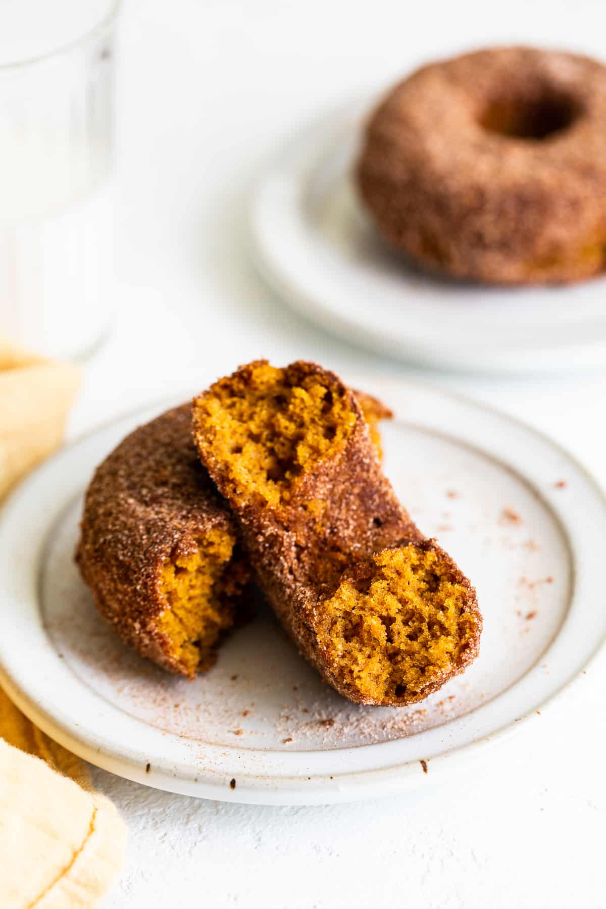 baked pumpkin donuts with cinnamon sugar on plate.