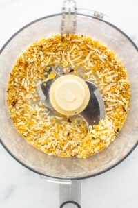 A food processor filled with nuts and seeds.