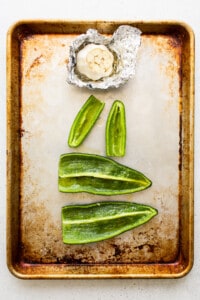 Peppers and garlic on a baking sheet.