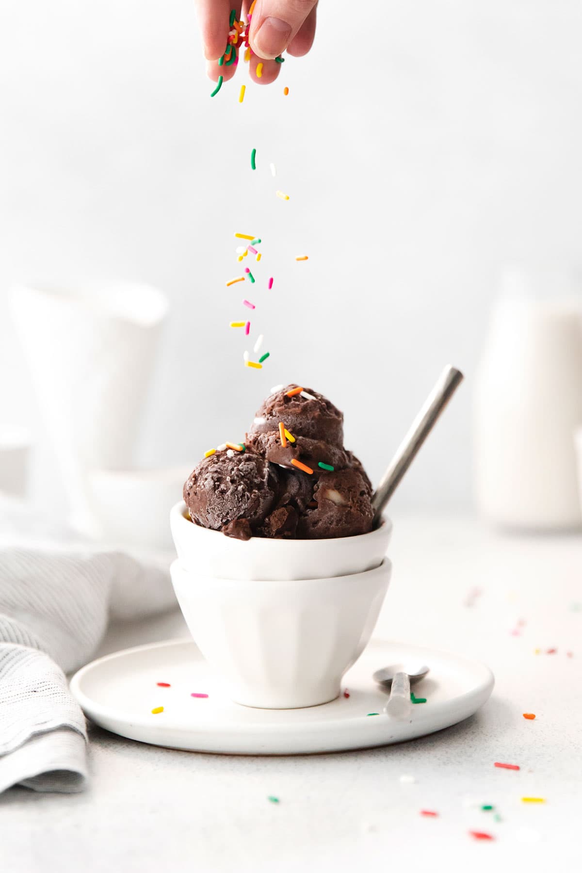 sprinkling sprinkles on ice cream.