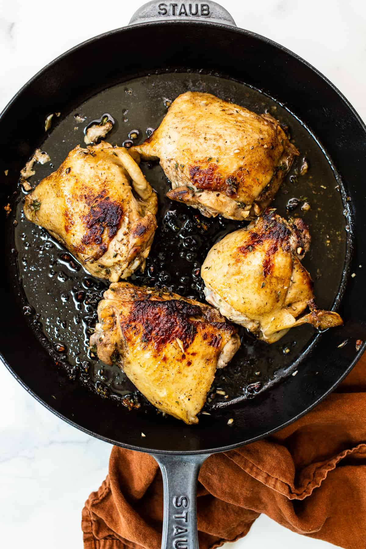 Browning chicken thighs in a cast iron skillet. 