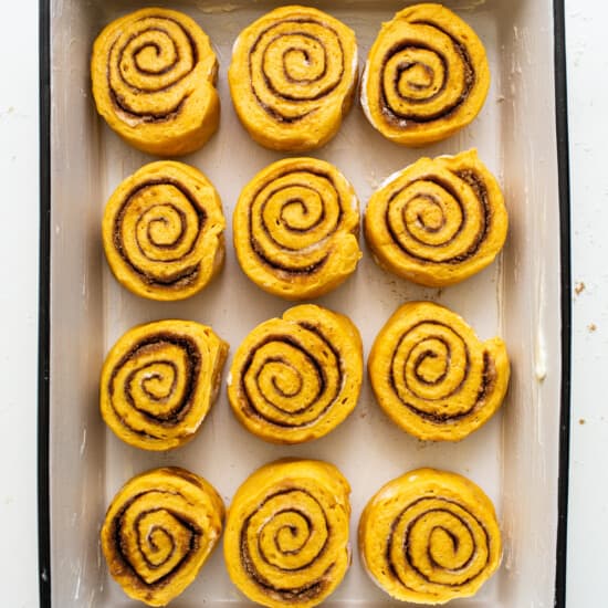 Pumpkin cinnamon rolls in a baking dish.