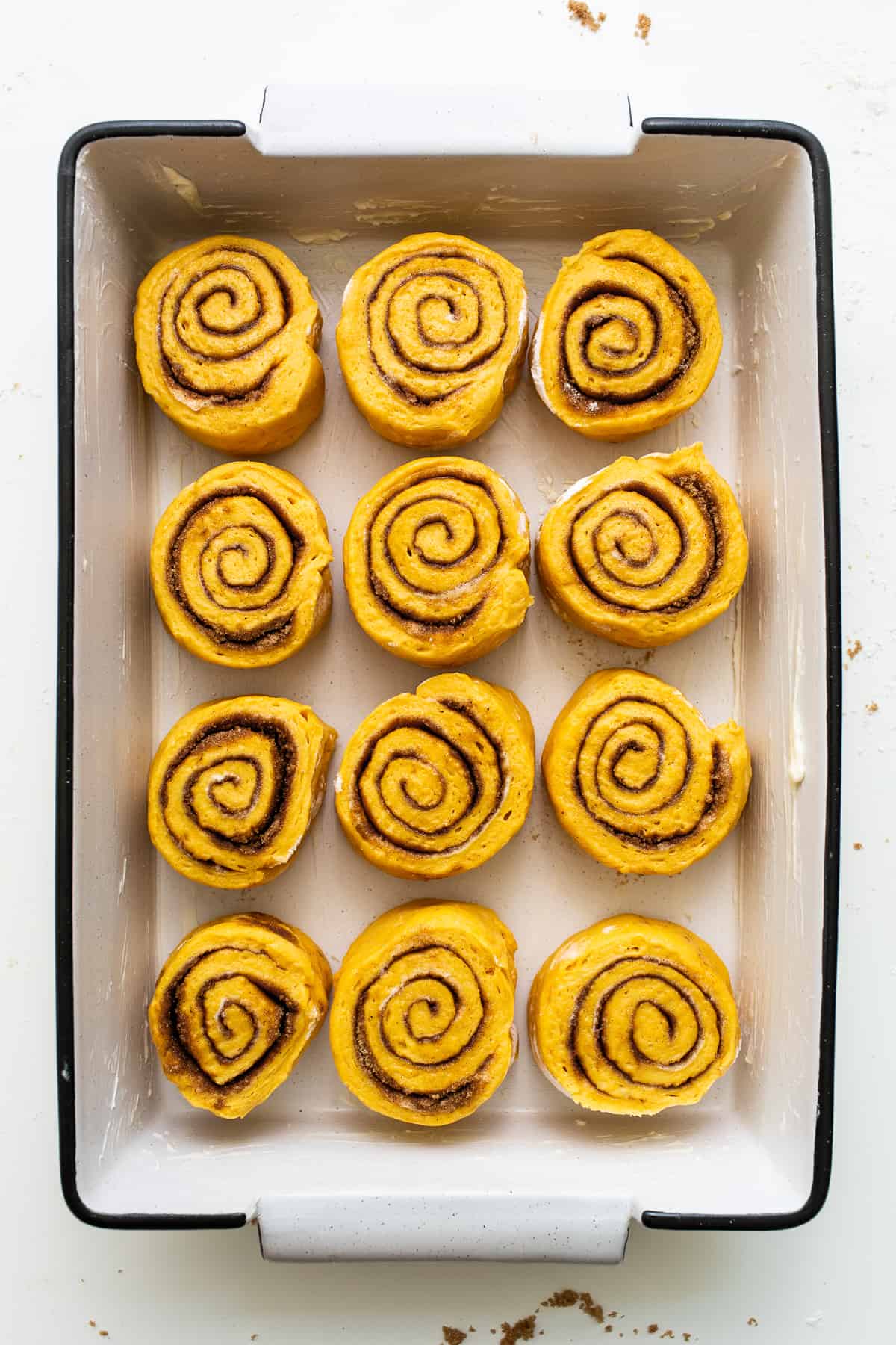 Pumpkin cinnamon rolls in a baking dish.