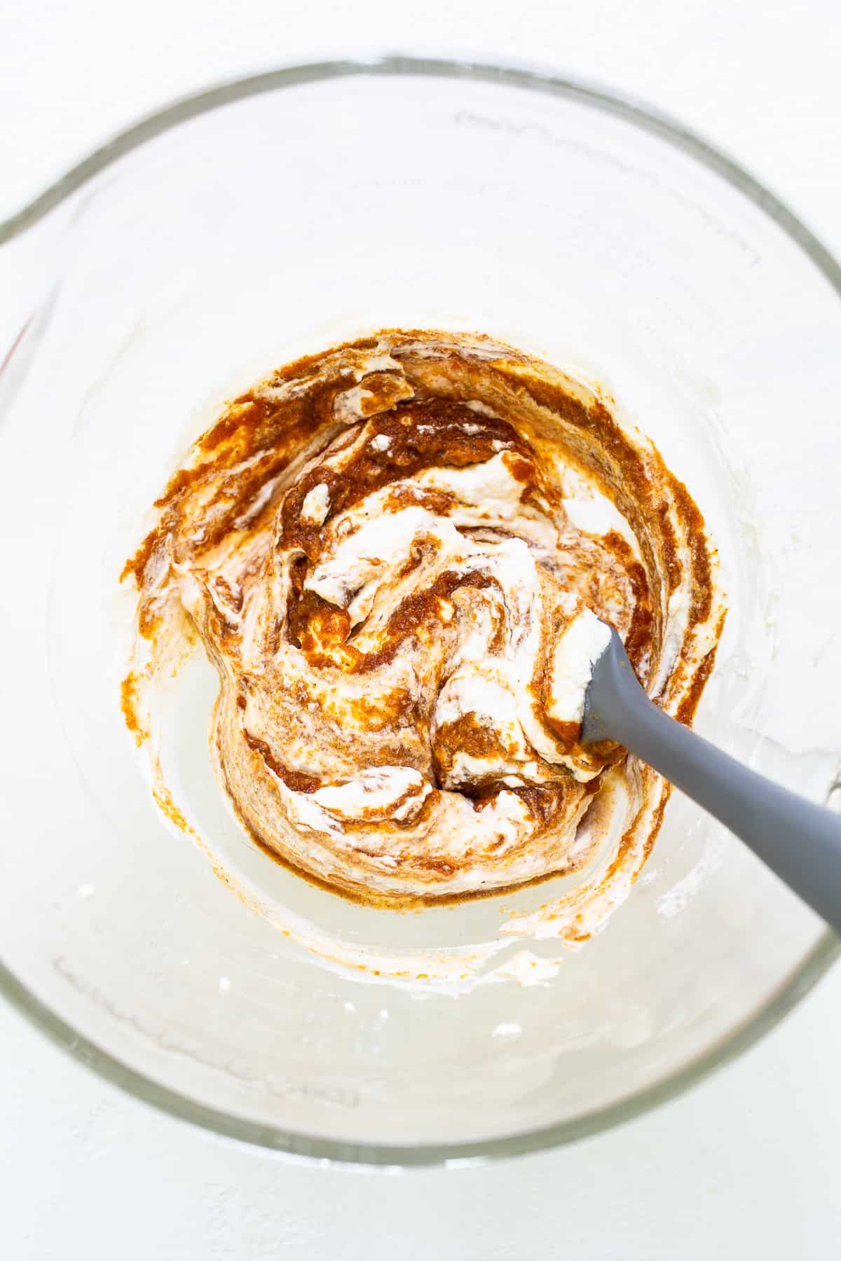 Pumpkin mixture with whipped cream for pumpkin mousse in a bowl.