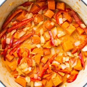 A pot filled with sweet potatoes and red peppers.