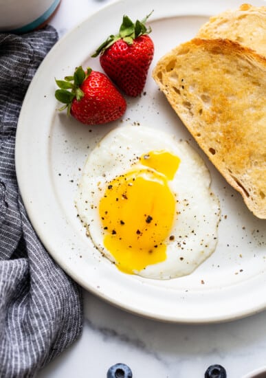 Sunny side up egg on a plate with toast.