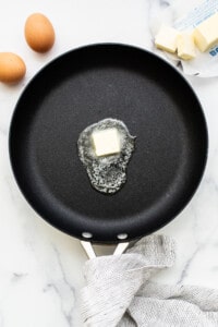 A pad of butter melting in a pan.