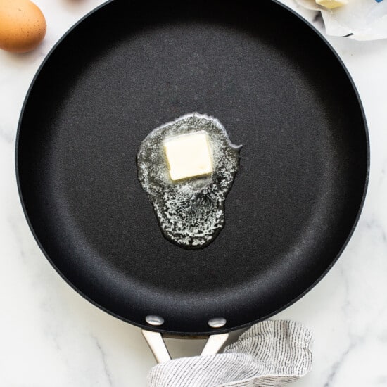 A pad of butter melting in a pan.