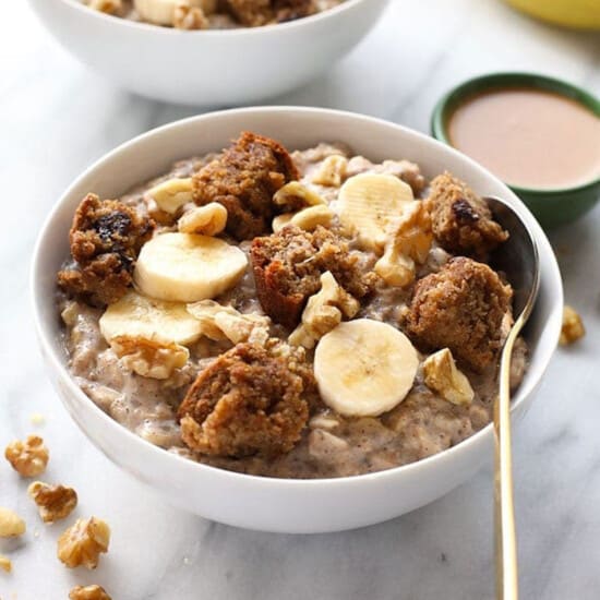 Two bowls of oatmeal with bananas and walnuts.