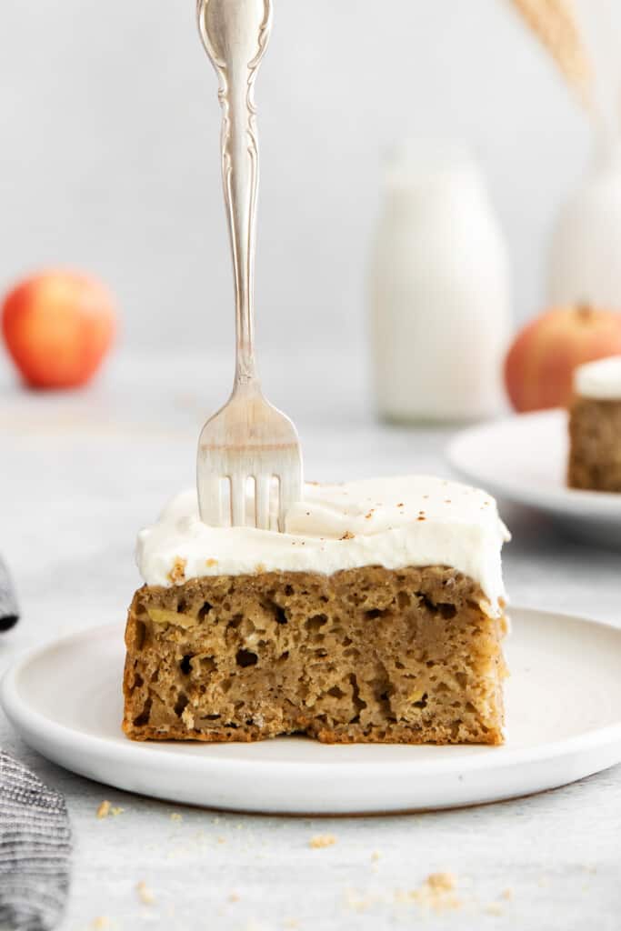A piece of apple cake with a fork in it. 