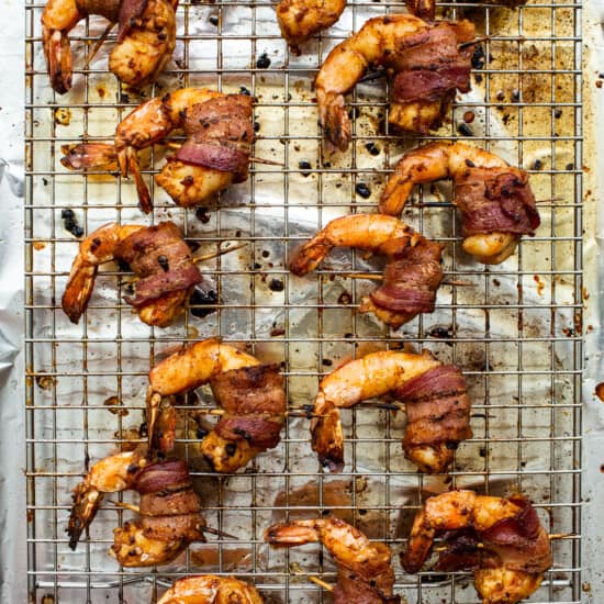 Bacon wrapped shrimp on a cooling rack.