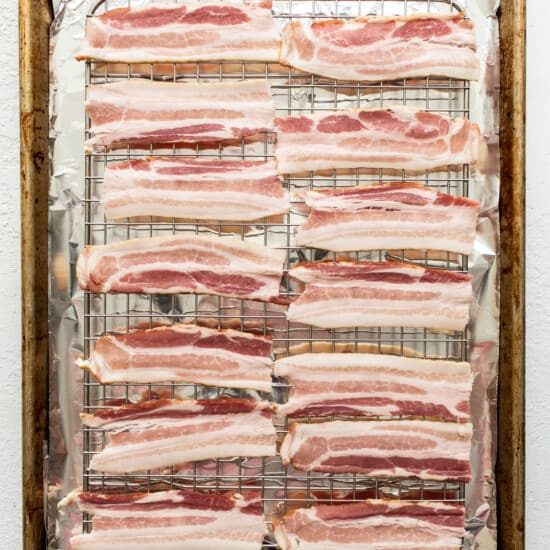 Bacon strips on a baking sheet.
