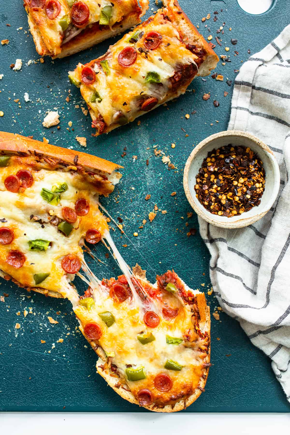 French bread pizza on a cutting board.