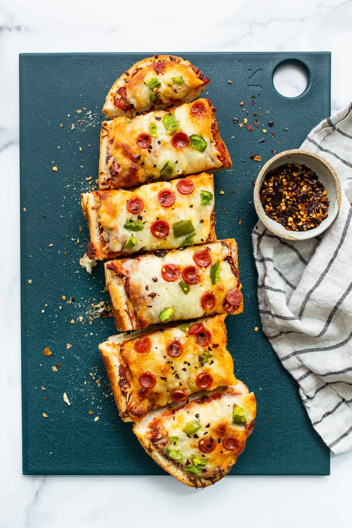 French bread pizza on a cutting board.