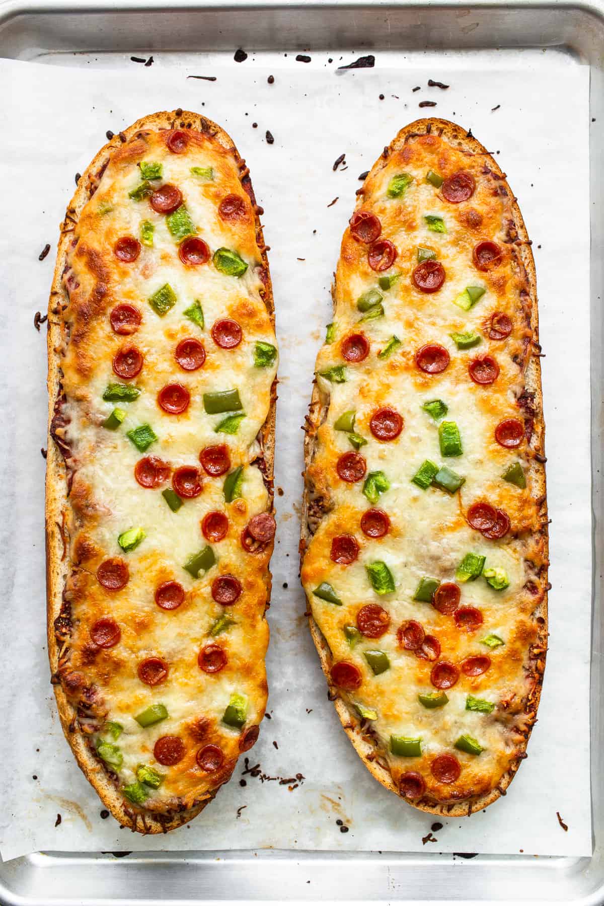 Cooked french bread pizza on a baking sheet.