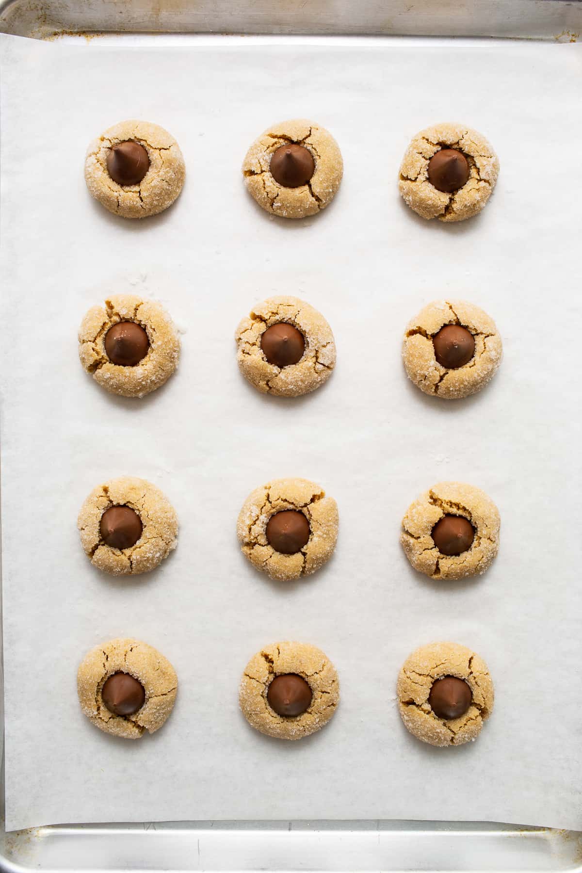 Peanut butter kiss cookies on a baking sheet.