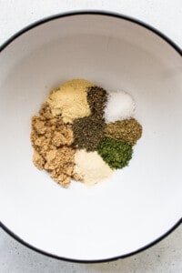 Spices in a bowl on a white surface.