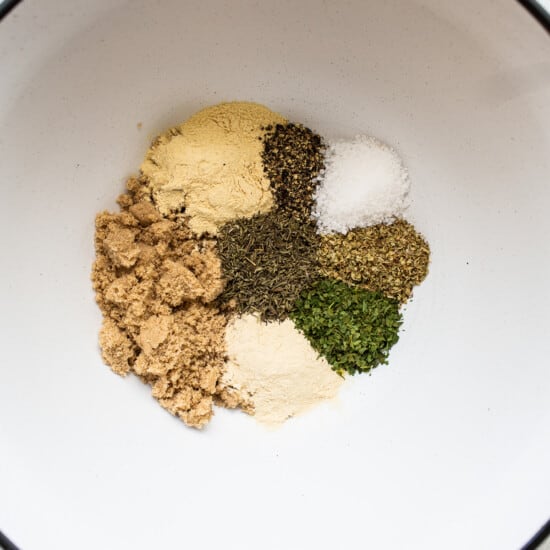 Spices in a bowl on a white surface.