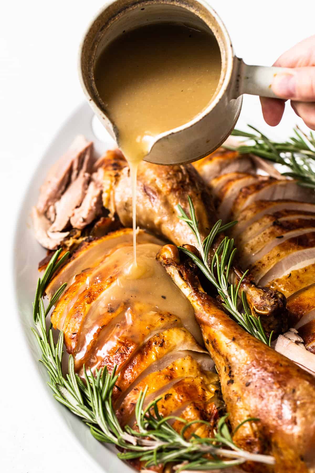 Turkey gravy being poured over sliced turkey.