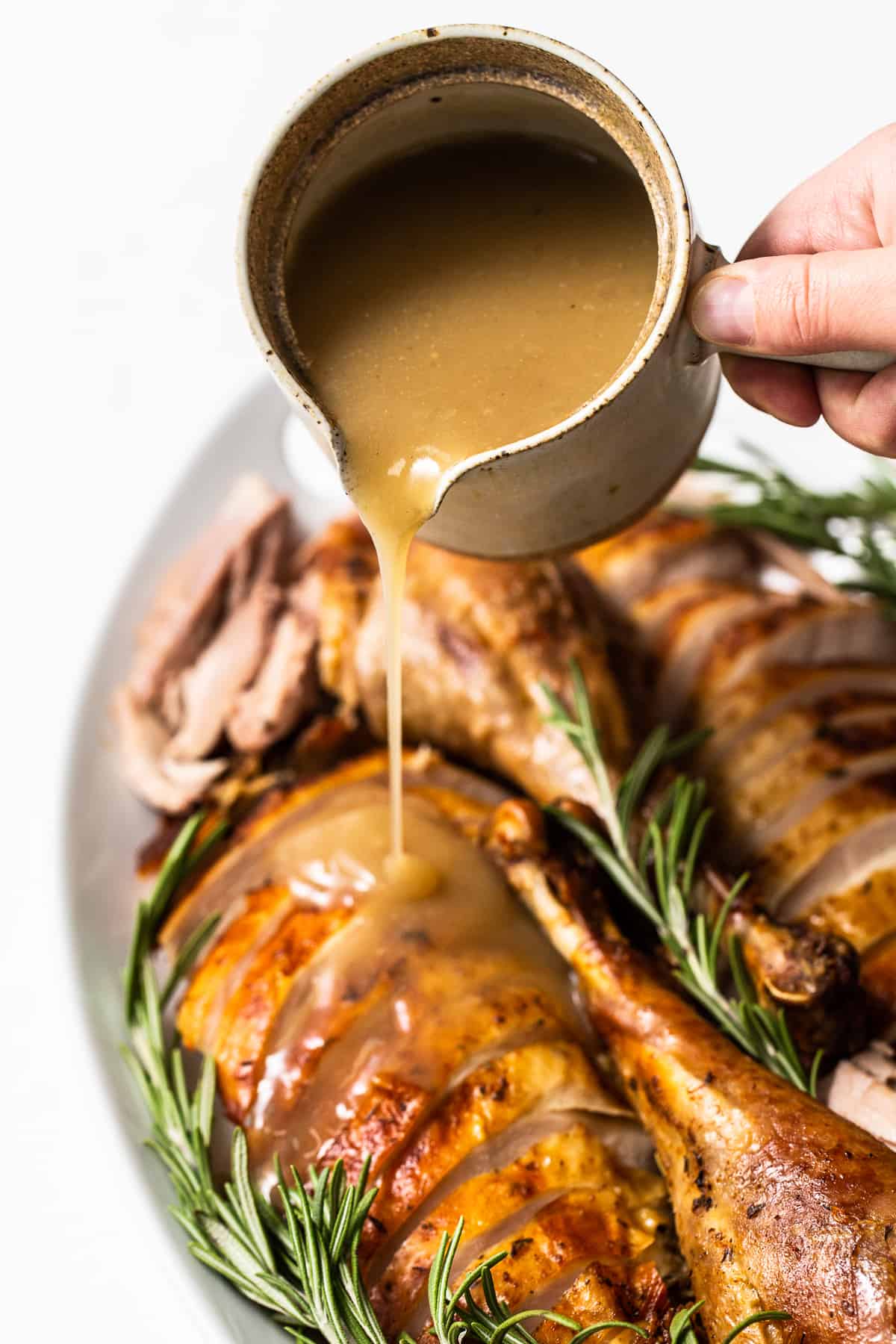 Turkey gravy being poured over sliced turkey.