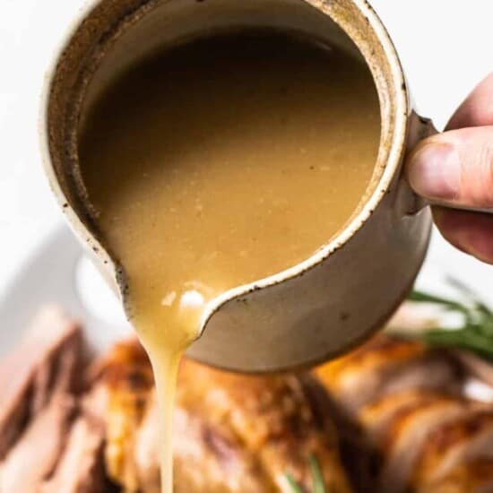 Turkey gravy being poured out of a cup
