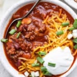 Slow cooker chili with sour cream and green onions.