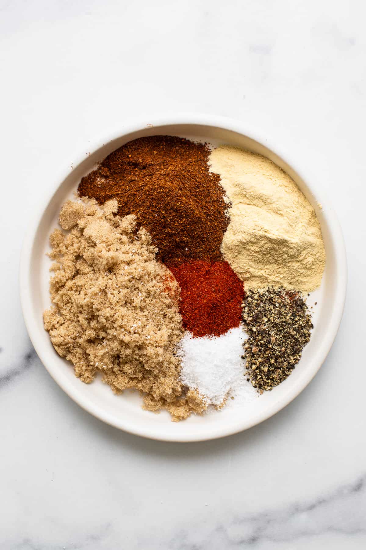 Ingredients for pork chops dry rub on a plate.