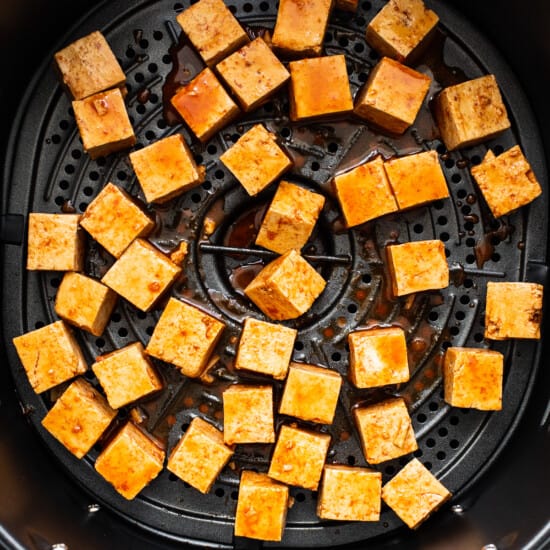 Placing the tofu in the air fryer.