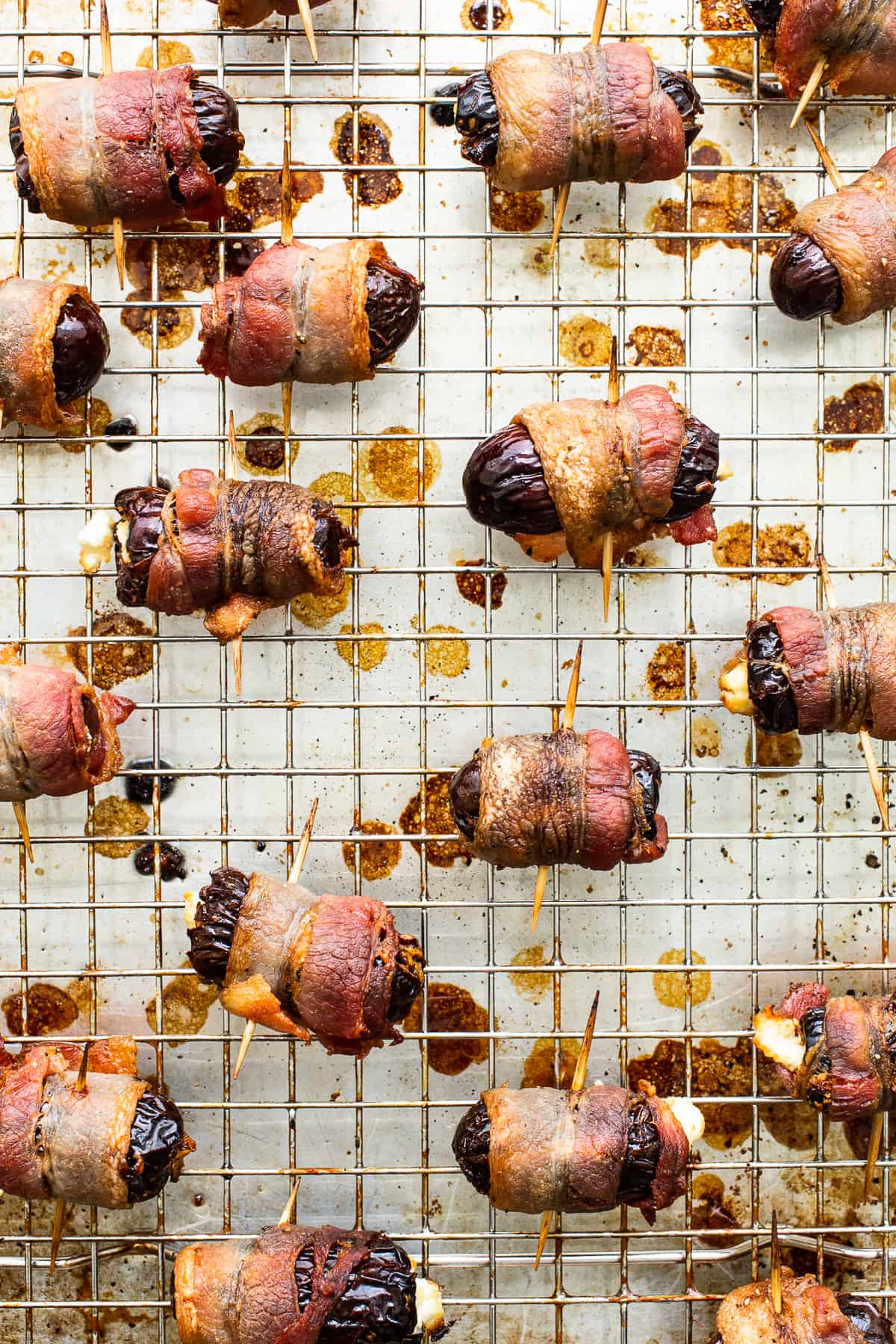 Bacon wrapped dates with goat cheese on a baking sheet.