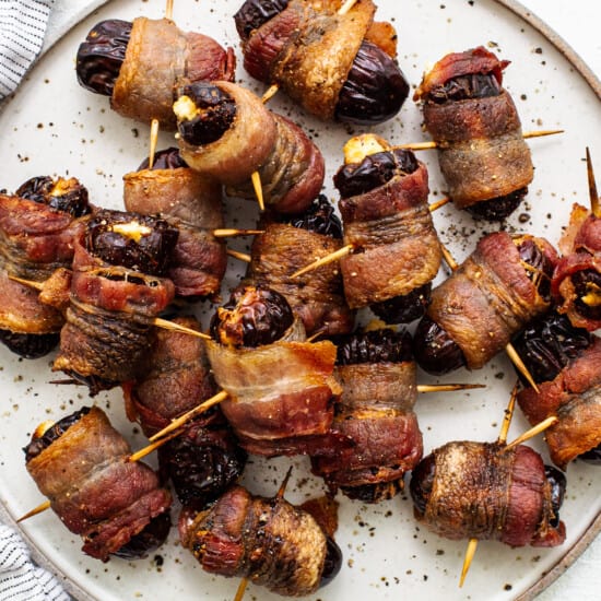 Bacon wrapped dates on a plate.