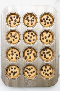 Chocolate chip muffins in a muffin tin.