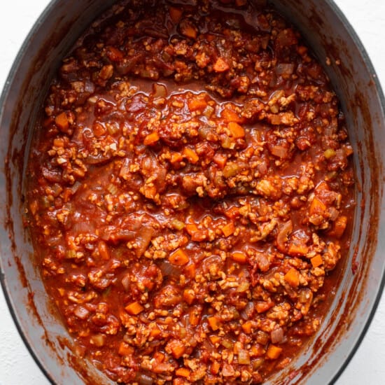 A pot full of chili in a white pot.