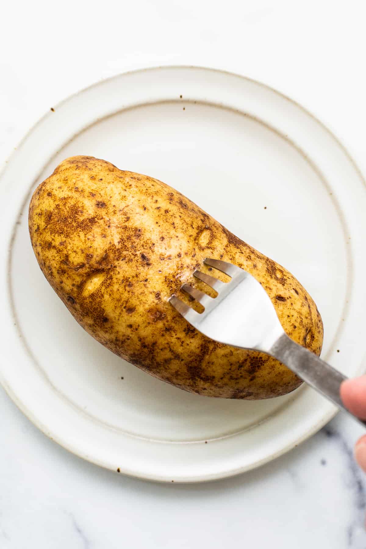 Poking holes in a potato with a fork.