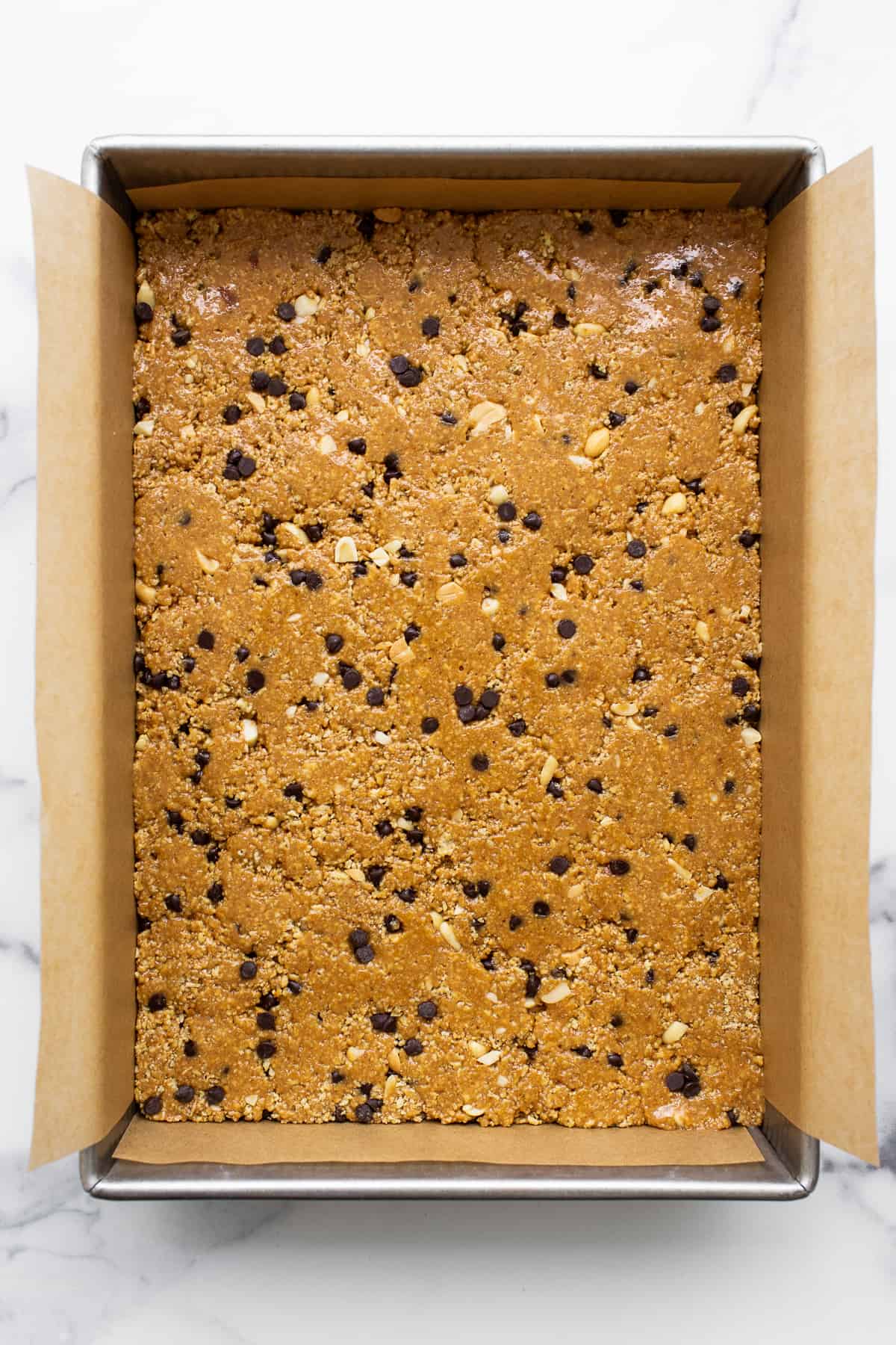 No bake peanut butter bars pressed into a cake pan.