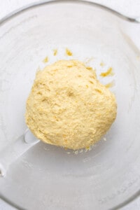 Orange roll dough in an oiled bowl.